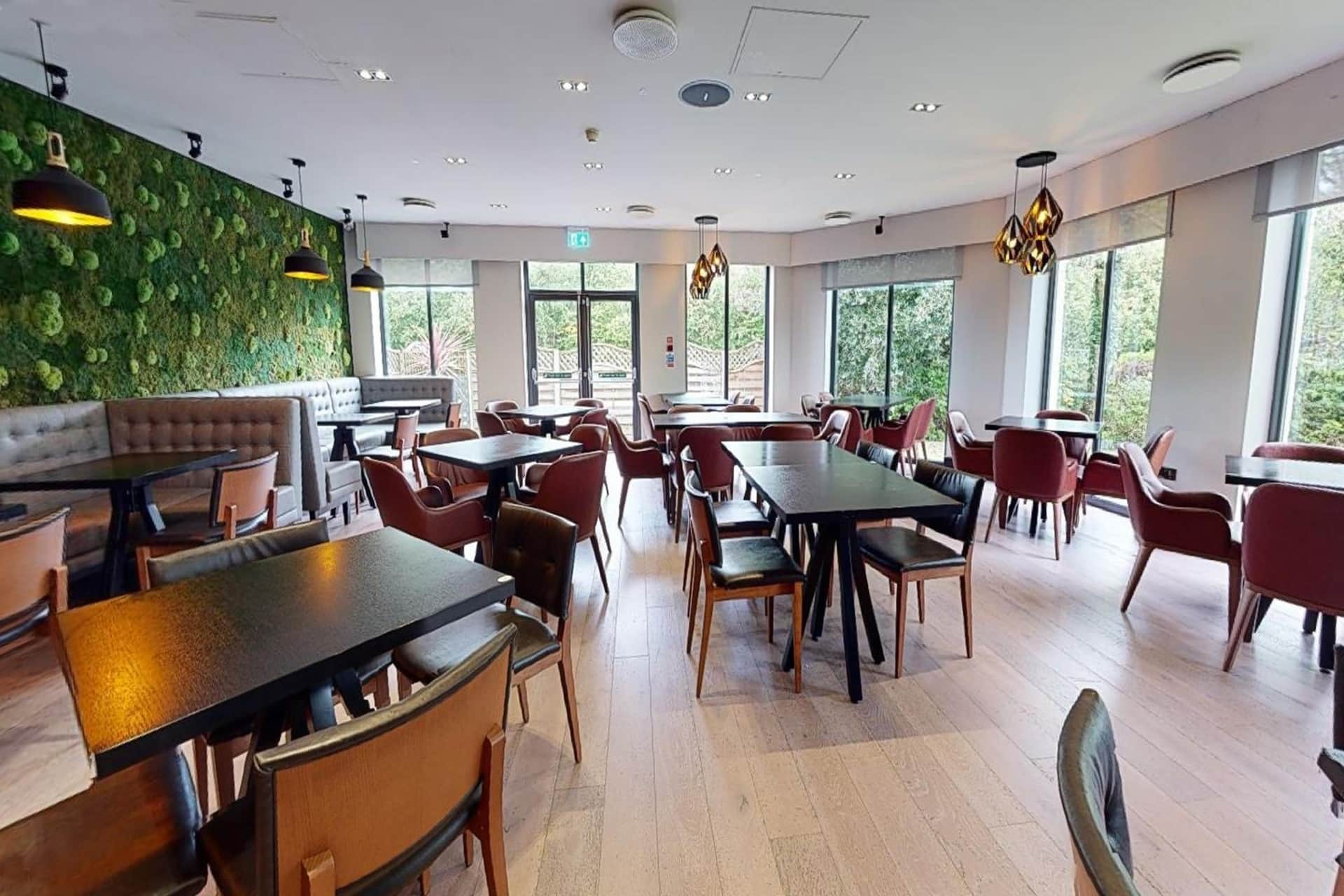 Village Hotel St Davids - the restaurant with moss wall, booth seating and floor-to-ceiling windows